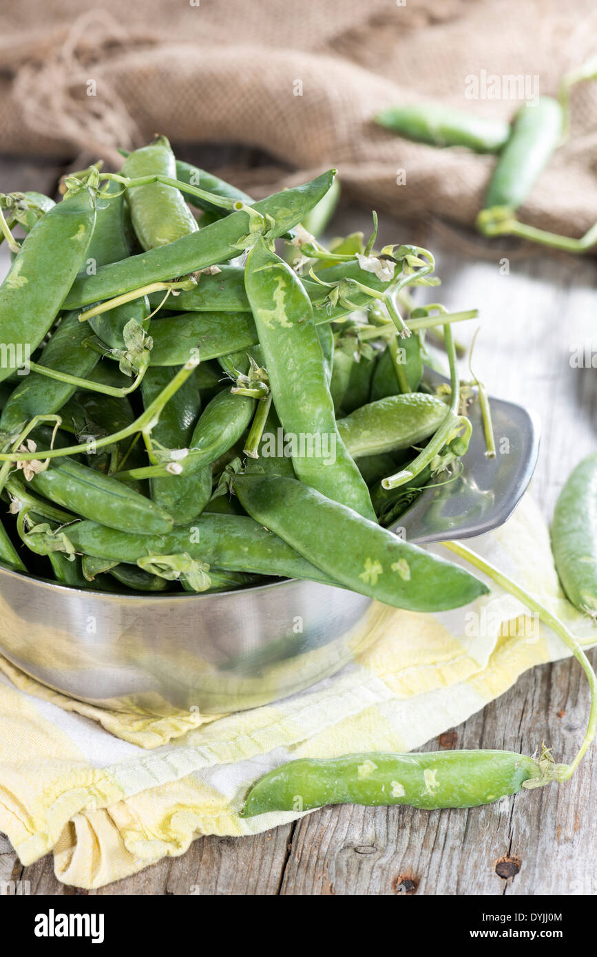 Portion of fresh pea pods in a bowl on wooden background Stock Photo