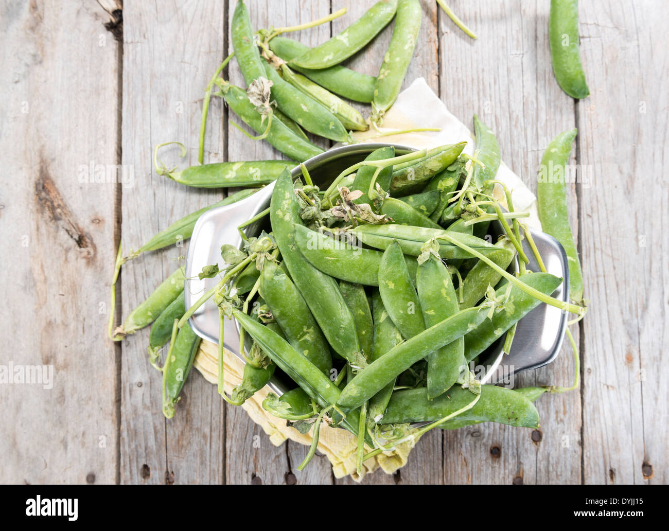 Portion of fresh pea pods in a bowl on wooden background Stock Photo
