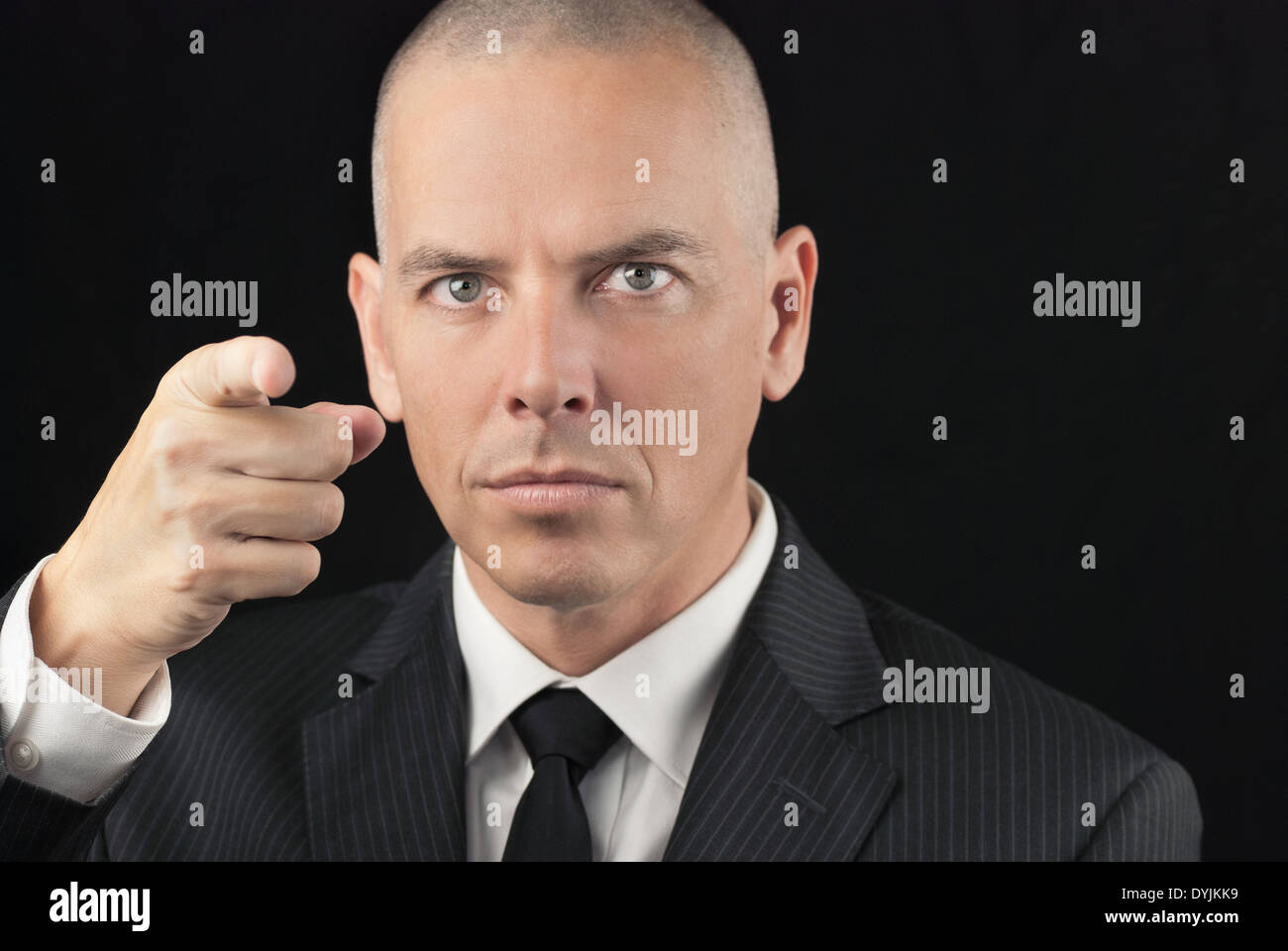 Close-up of an intense bald man pointing to camera. Stock Photo
