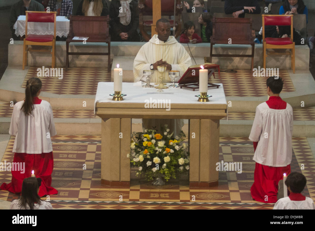 Wimbledon London, UK. 20th April 2014. A priest gives blessings as a large faithful congregation attends mass on Easter Sunday at the Sacred Heart Catholic Church in Wimbledon Stock Photo