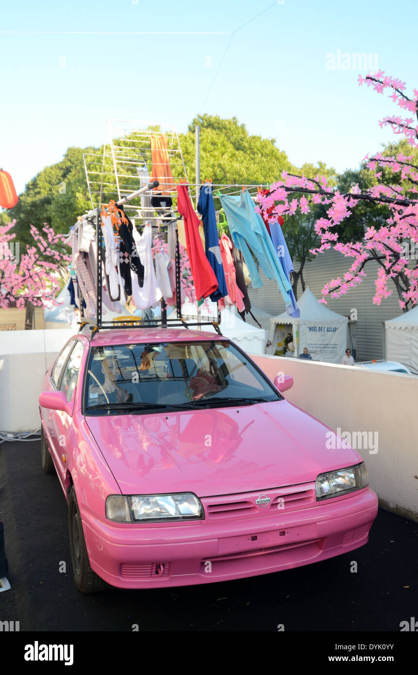 Pink Nissan Car Pink Blossom & Portable Clothes Drier Attached to Car. Useless Japanese Gadget or Chindogu. Stock Photo