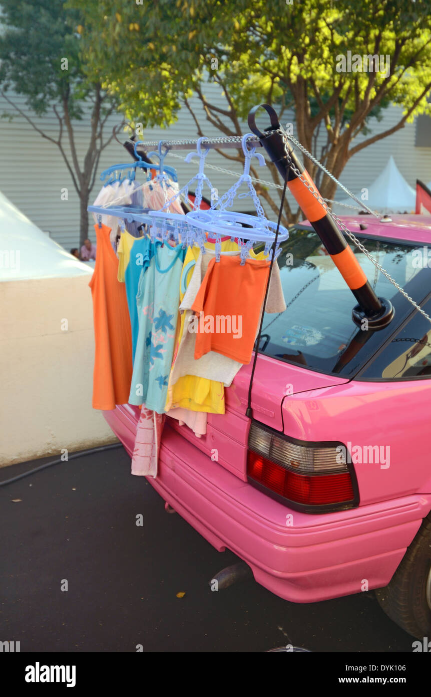 Portable Clothes Drier or Line Attached to on a Pink Nissan Car. Useless Japanese Gadget or Chindogu. Stock Photo