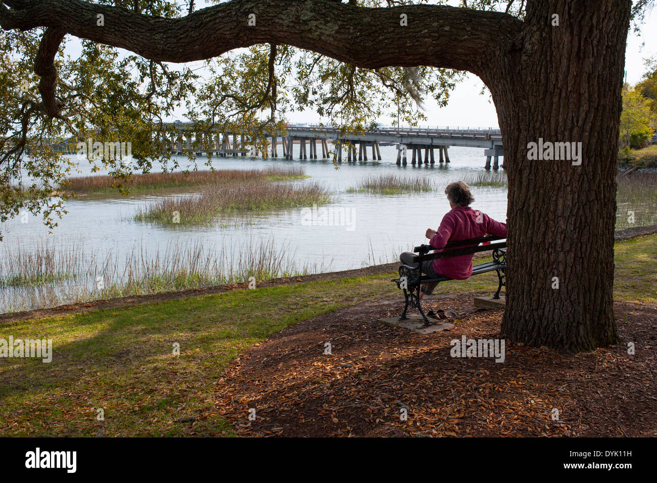 USA South Carolina SC Beaufort man sitting on a bench looking out to Beaufort River and Woods Memorial Bridge Stock Photo