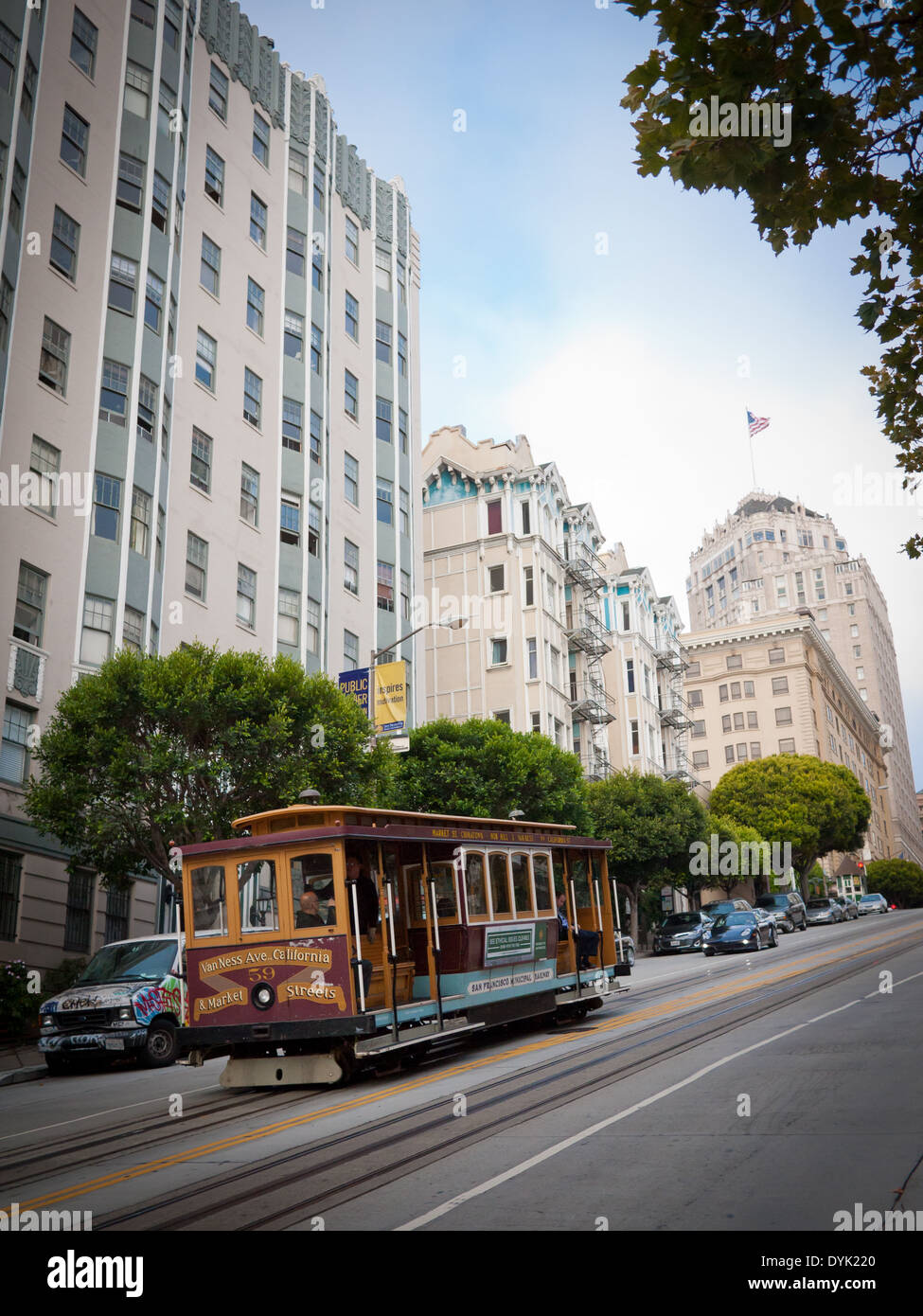 A California Street cable car rumbles down Nob Hill in San Francisco, California. InterContinental Mark Hopkins Hotel at right. Stock Photo