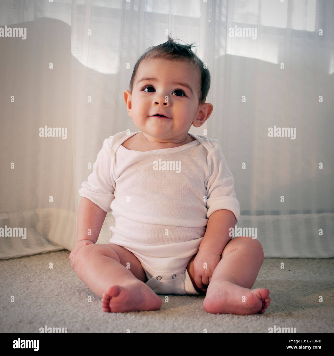 Cute baby sitting in living room Stock Photo