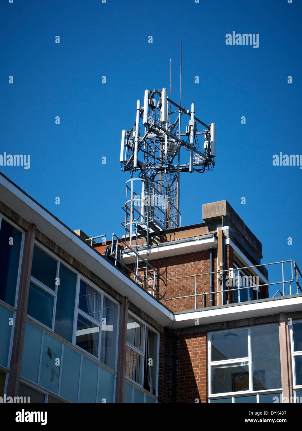 Mobile phone transmitter mast on top of office building UK Stock Photo