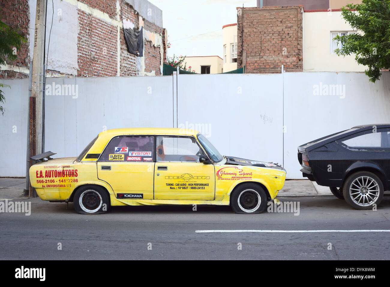 Yellow car with flat tires and many advertisements in Lima, Peru Stock