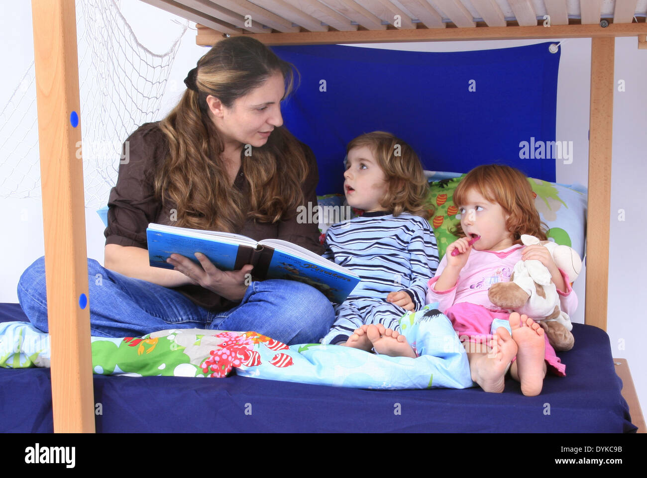 mother reading a book to her children in a Billi-Bolli loft bed, Stock Photo