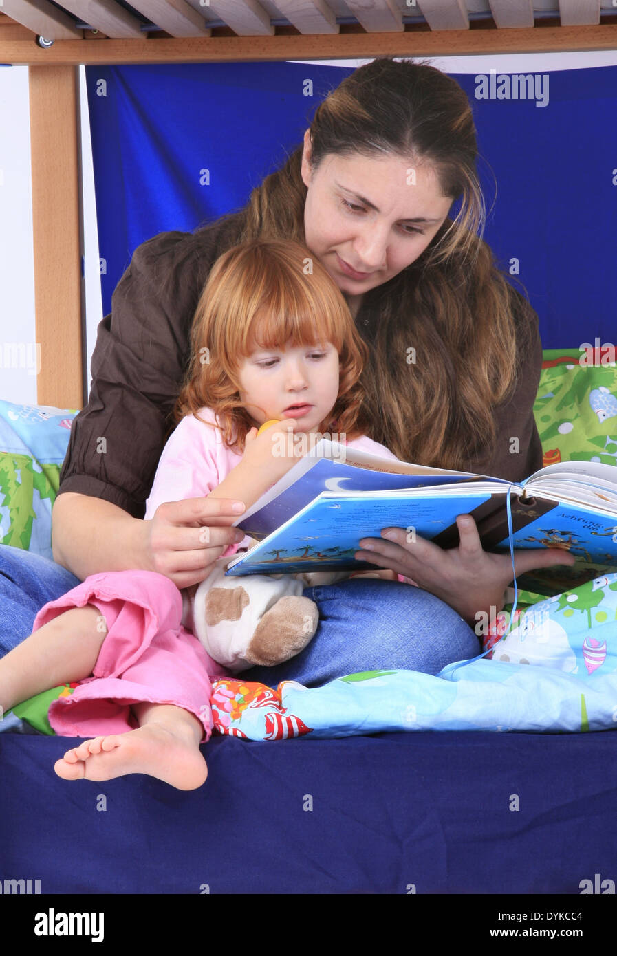 mother reading a book to her daugter in a Billi-Bolli loft bed, Stock Photo