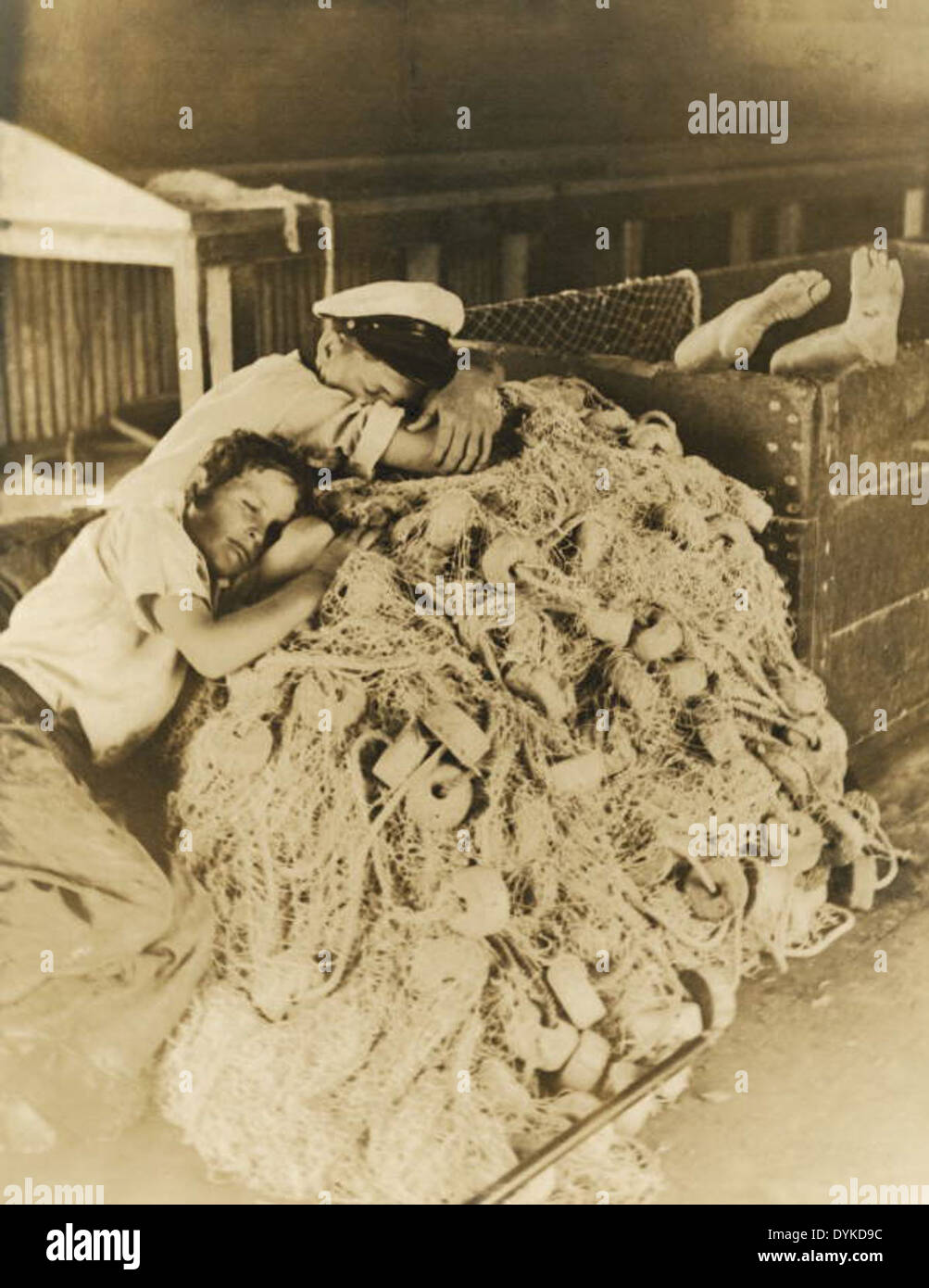 Boys sleeping on idle fishing nets in Riviera Beach, Florida Stock Photo