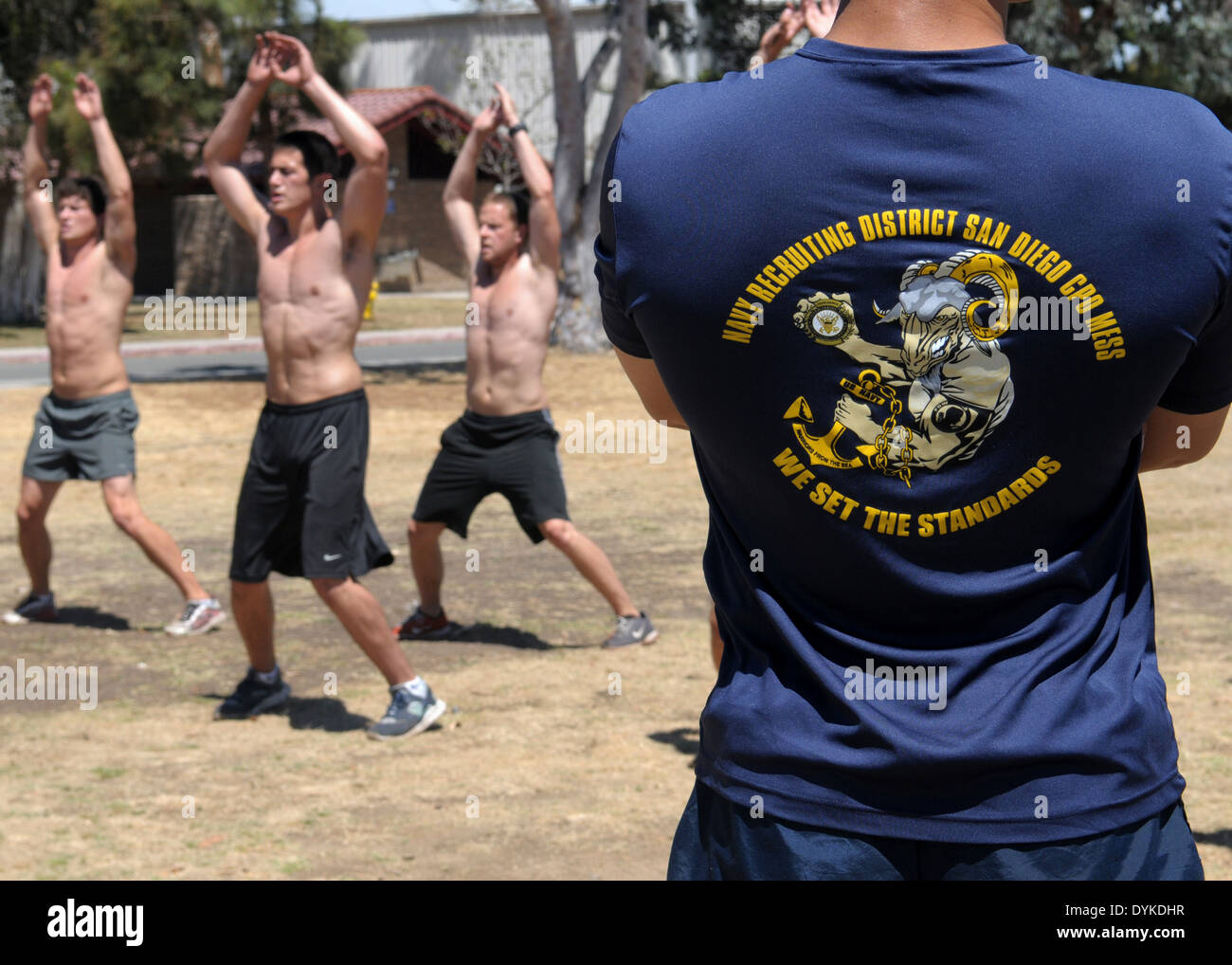 US Naval Special Warfare candidates perform jumping jacks during a Navy Recruiting District San Diego weekly Navy Special Warfare physical screening test June 24, 2013 in San Diego, Calfornia. Navy Recruiting Command conducts the program to find the top candidates to fill Navy Special Warfare billets, which include SEAL, explosive ordnance disposal, special warfare boat operator, Navy diver, and naval air crewman positions. Stock Photo