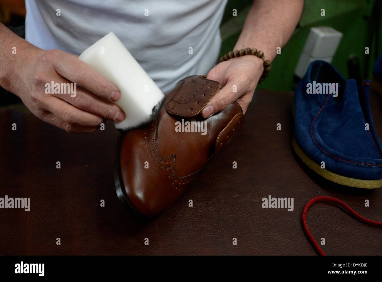 Walheim, Germany. 15th Apr, 2014. An employee of the German shoe