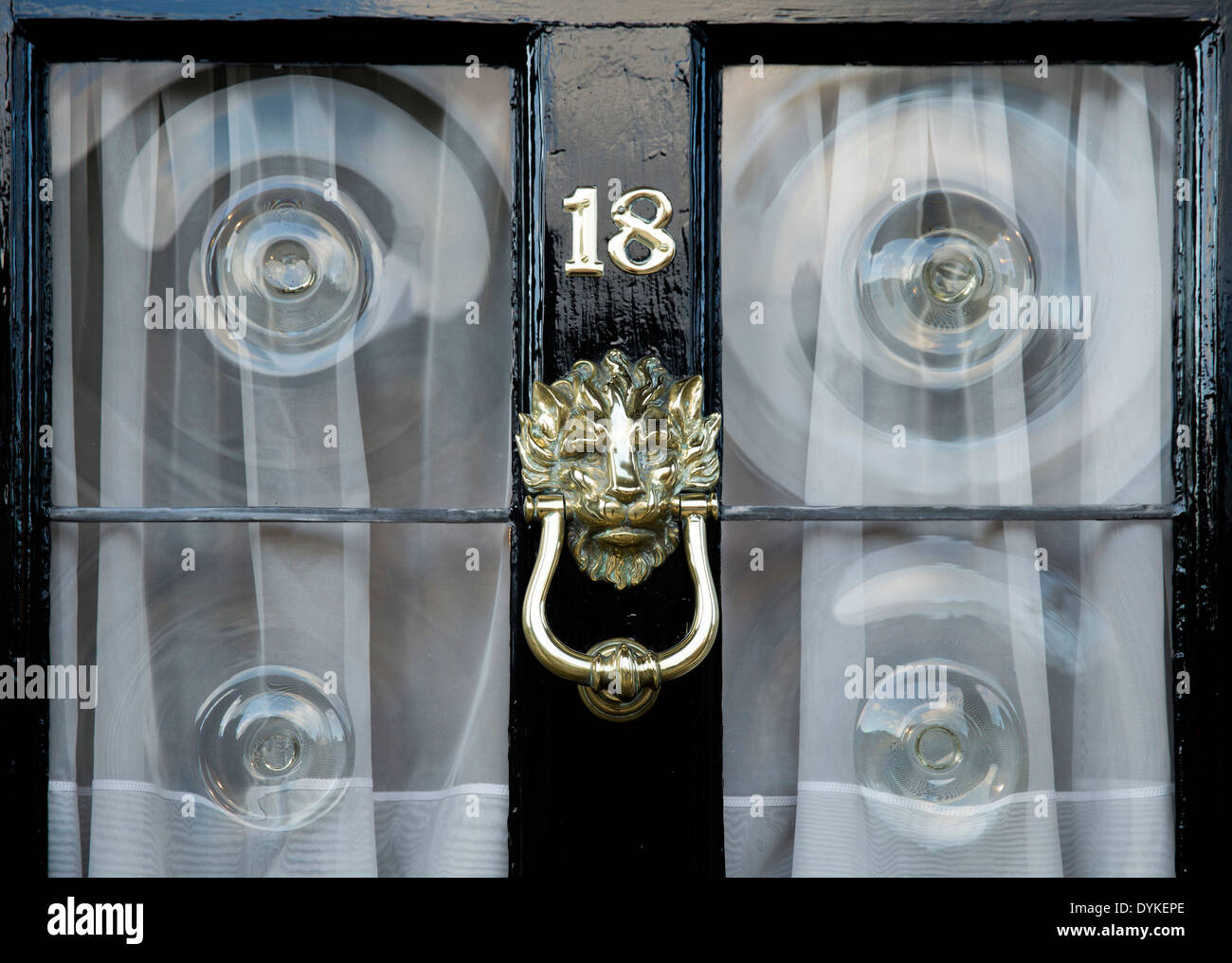 number 18 door with an ornate knocker and glass spirals on a street in Lincoln, UK. Stock Photo