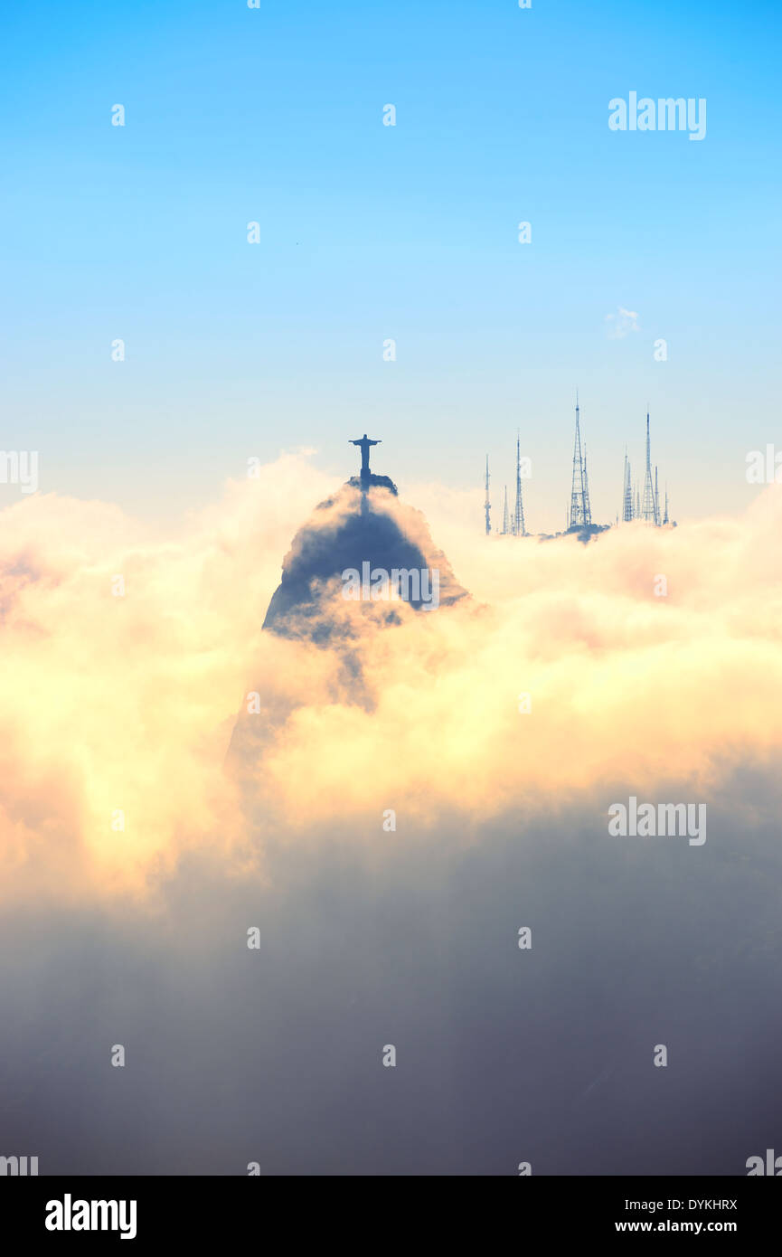 Corcovado mountain Christ the Redeemer standing above golden swirling mist clouds Rio de Janeiro Brazil Stock Photo