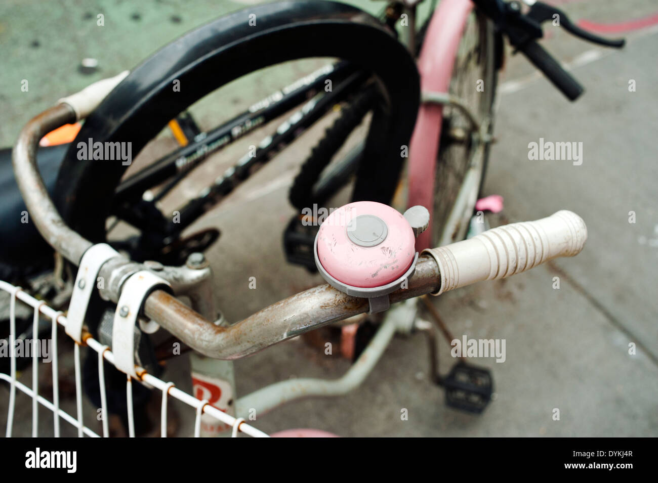 An old pink bicycle with matching pink bell Stock Photo