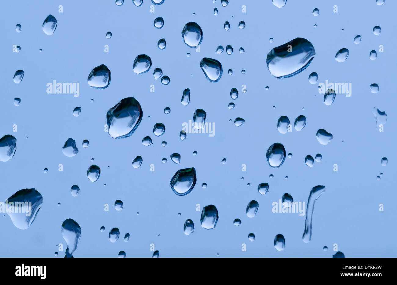 Drops of rain, rain droplets, raindrops or water drops on a window. Stock Photo