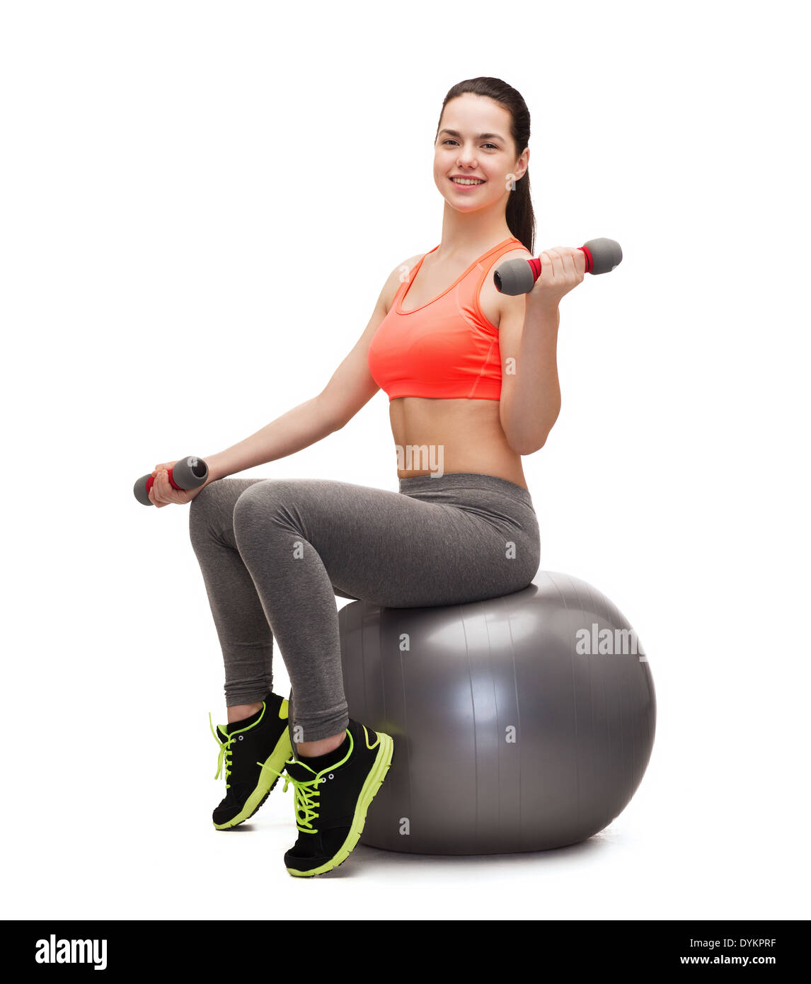 teenager with dumbbells sitting on fitness ball Stock Photo