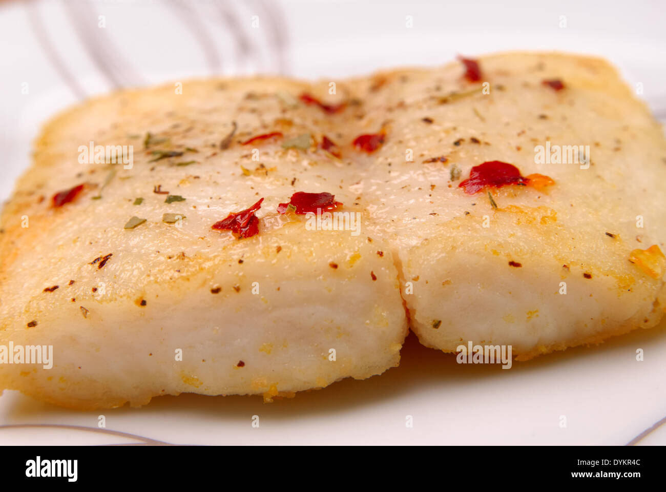 Catfish with aromatic herbs served on a white plate. Shallow depth of field Stock Photo