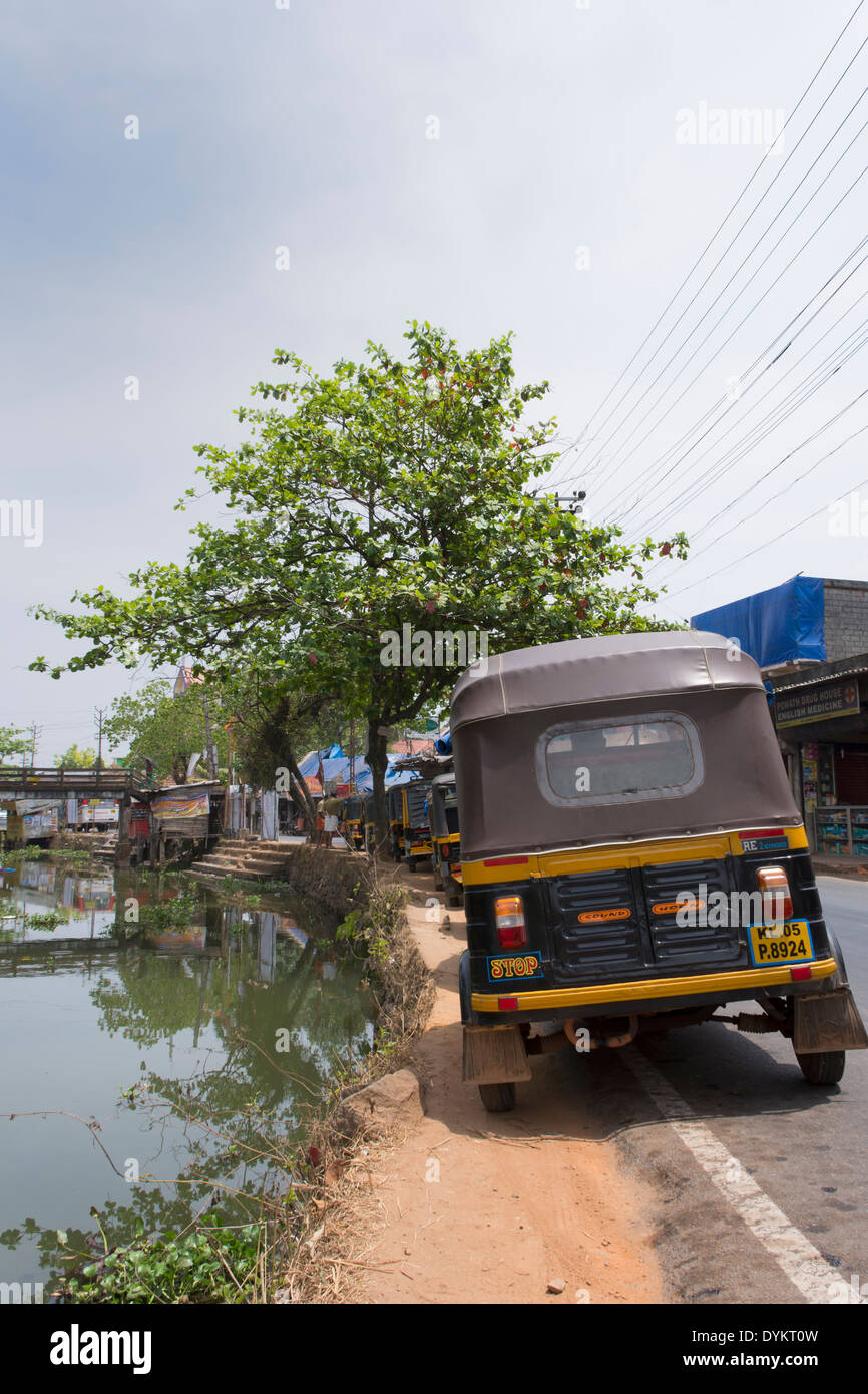 Auto Rickshaws parked by a waterway in the Backwaters of Kerala in India Stock Photo