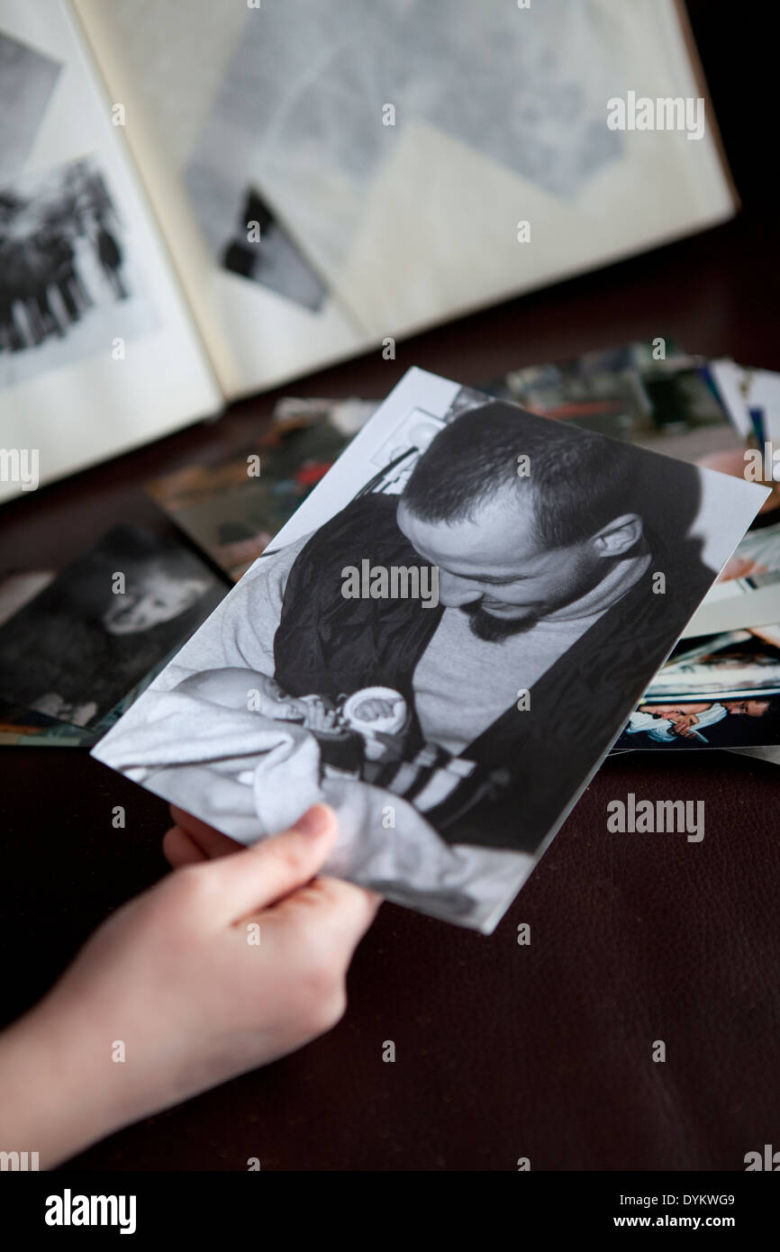 Child's hand holding an old black and white photo of man and baby taken ...