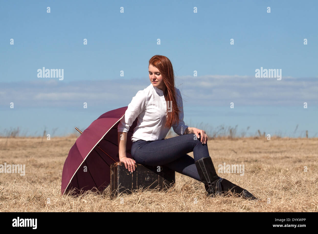 Red haired girl with vintage bag and umbrella Stock Photo