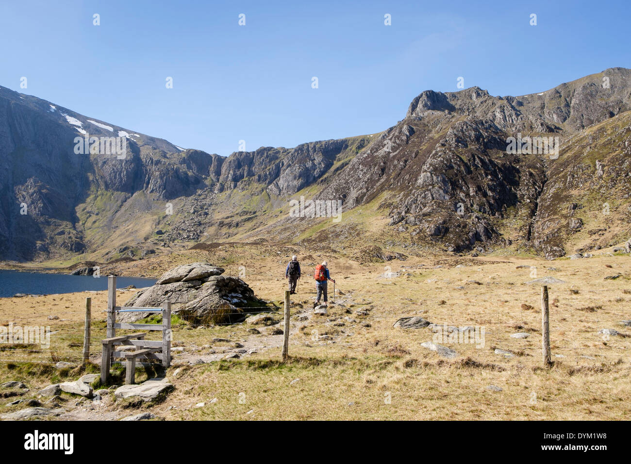 Cwm Idwal with 2 walkers heading to southeast ridge of Y Garn in mountains of Snowdonia National Park Ogwen North Wales UK Stock Photo