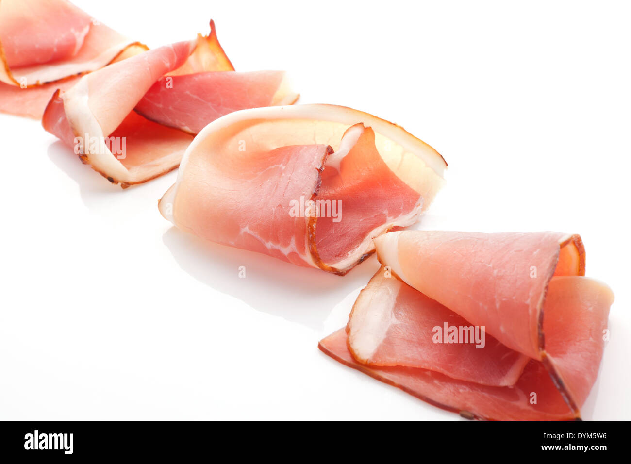 Prosciutto slices arranged isolated on white background. Culinary traditional meat. Stock Photo