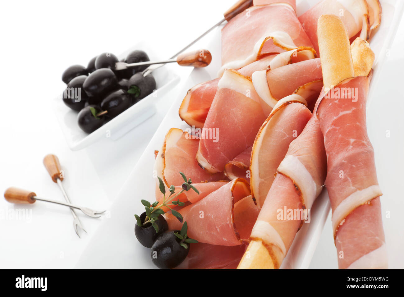 Delicious prosciutto with grissini breadsticks, black olives and fresh