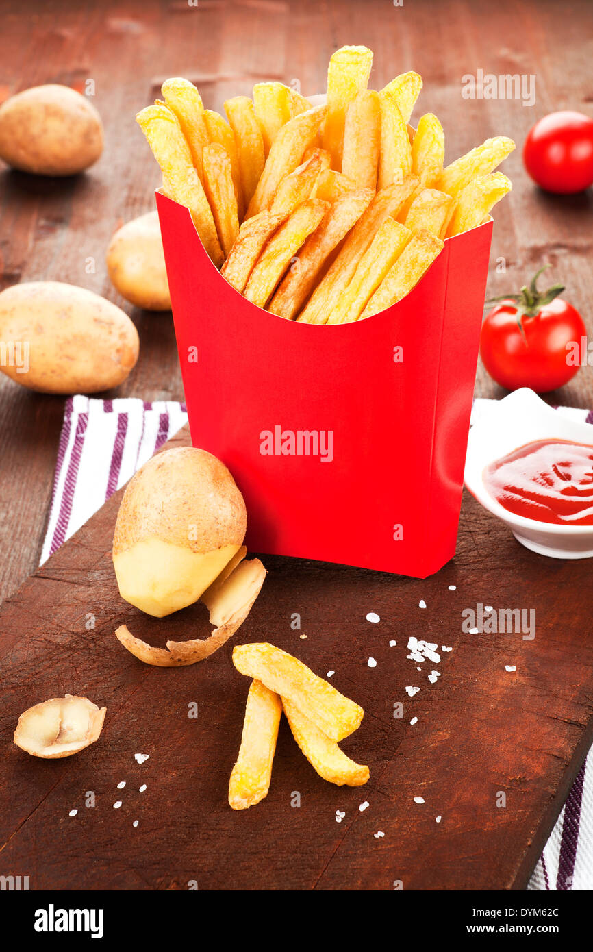 Mediabakery - Photo by Radius Images - Seasoned French Fries in Paper Bag  with Wooden Fork and Ketchup Studio Shot