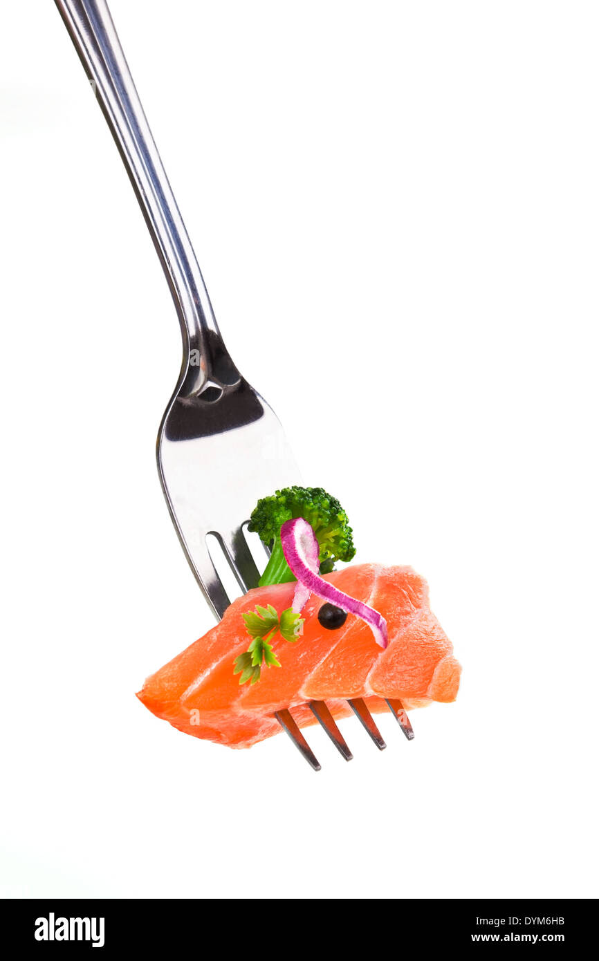 Salmon piece with broccoli, onion, pepper corn and herb arranged on fork isolated on white background. Stock Photo