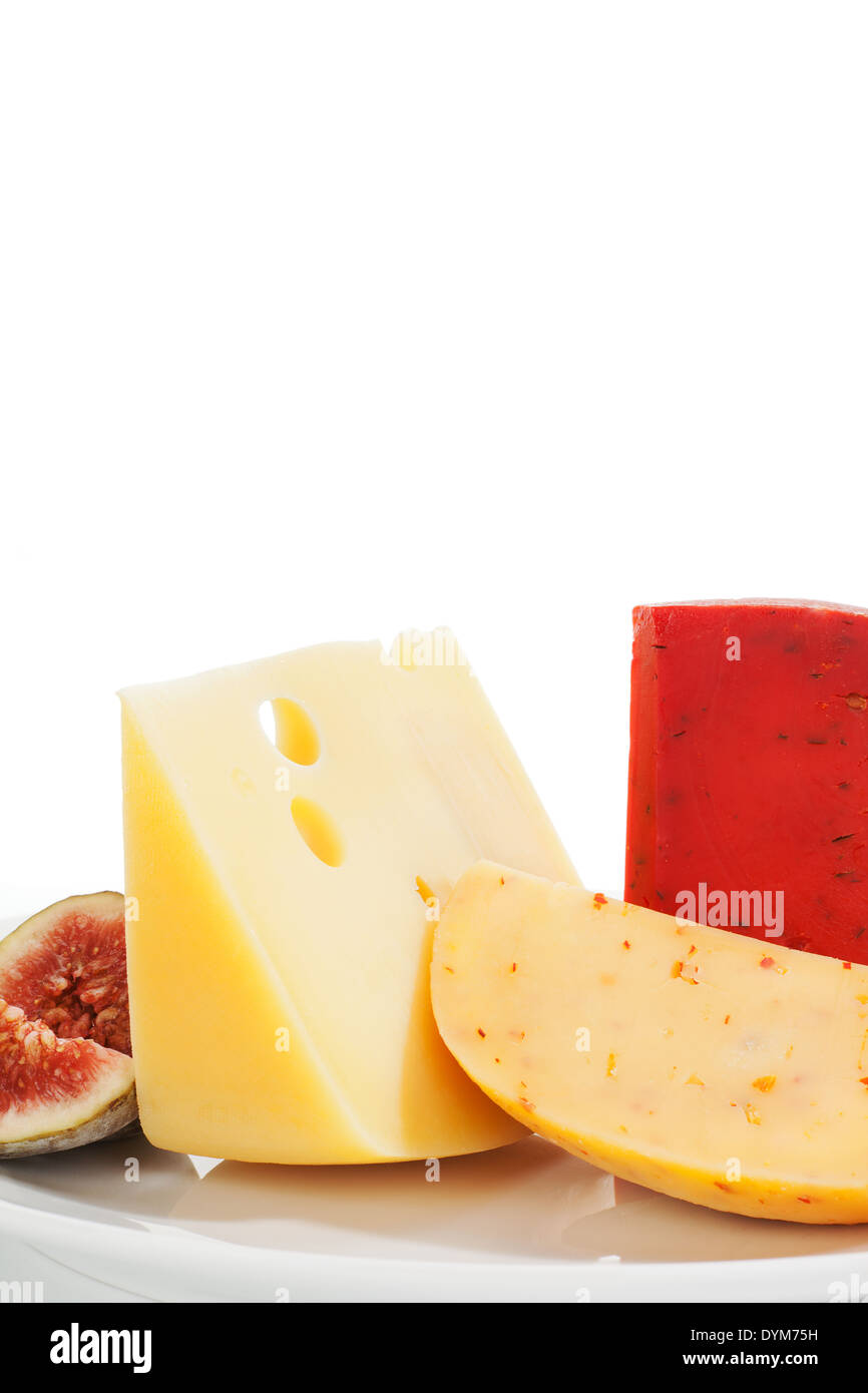 Colorful luxurious cheese background. Swiss cheese, gouda chlii and fig fruit on white plate isolated on white. Culinary eating Stock Photo