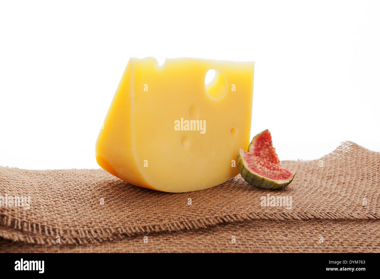 Luxurious swiss cheese emmentaler still life with fig on brown textile