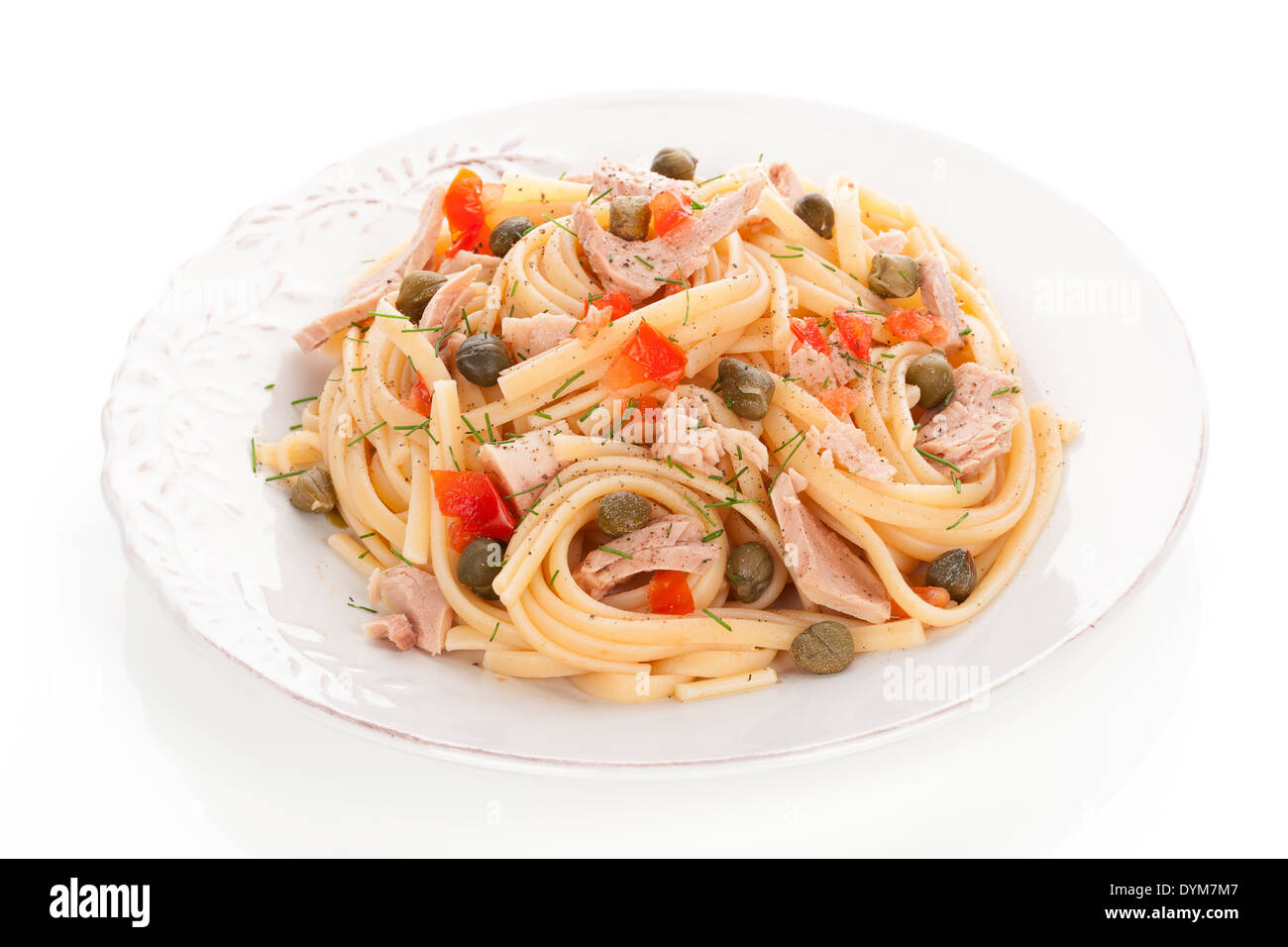 Culinary pasta with capers, tuna and vegetable on vintage plate isolated on white background. Luxurious culinary italian eating. Stock Photo