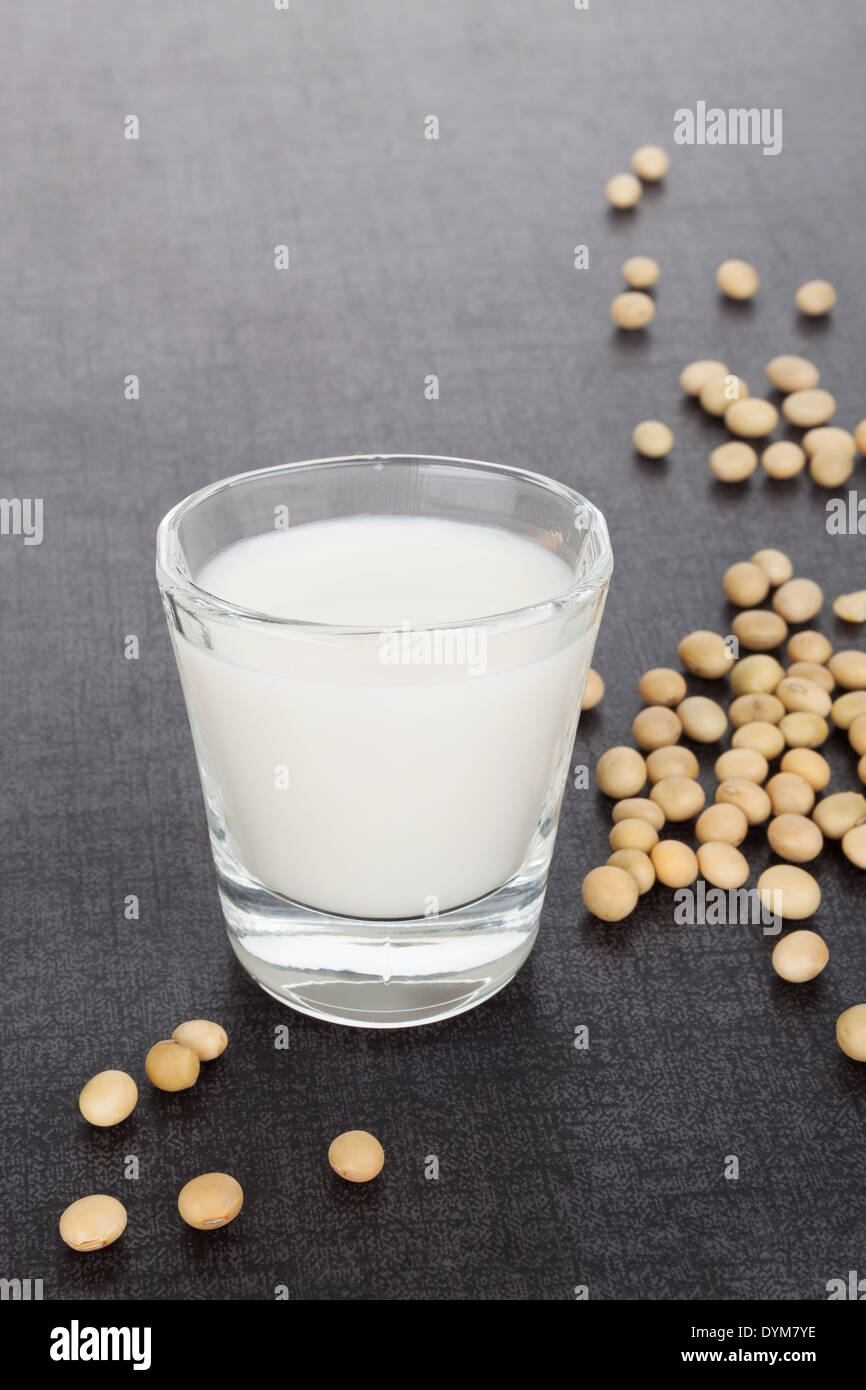 Soy milk with soybeans isolated on dark black and grey luxurious