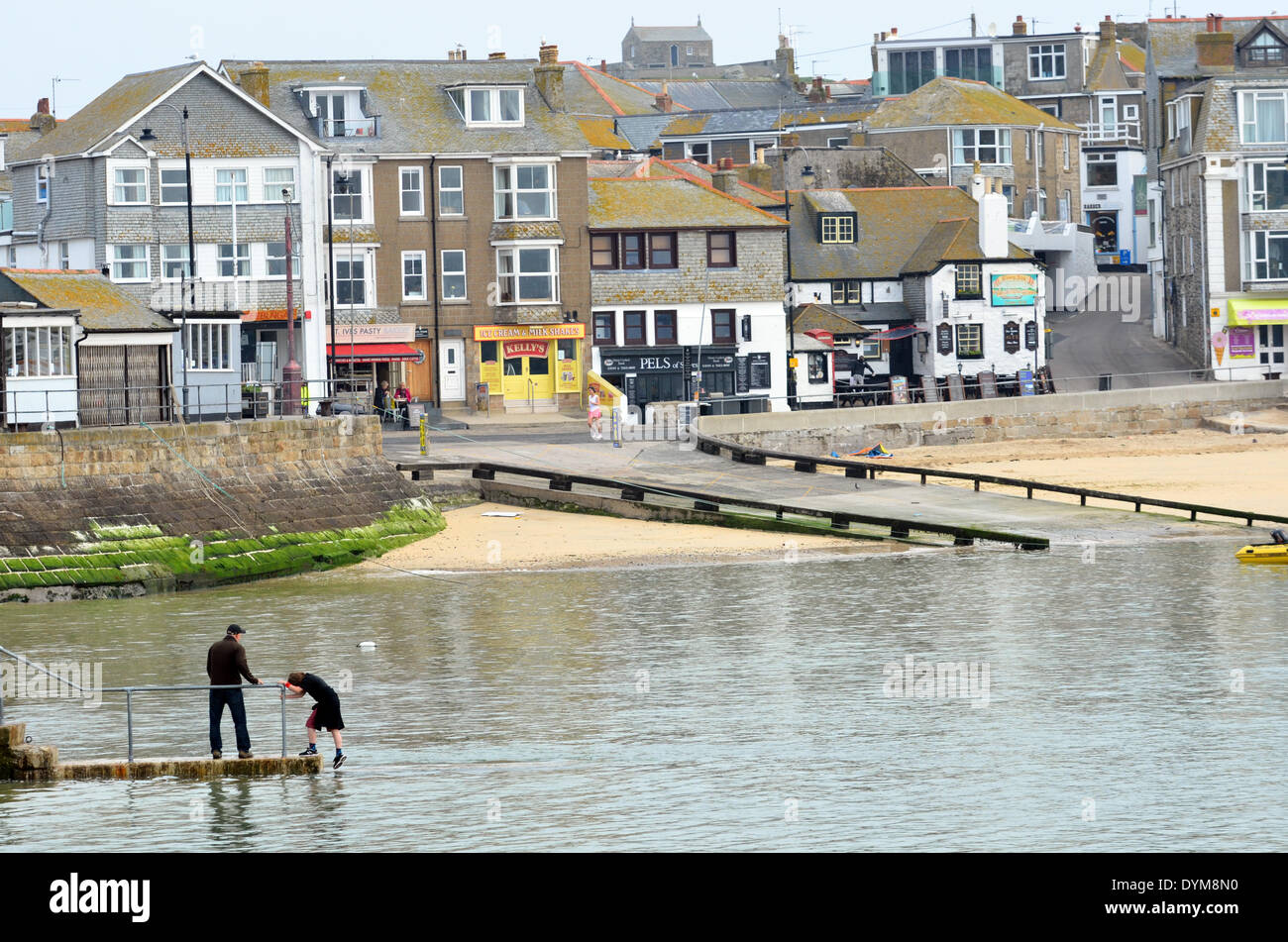 St Ives, Cornwall, UK. 22nd April 2014. Just testing the Water for a possible swim..Early Risers getting ready for the day ahead in St Ives Harbour. Credit:  Robert Timoney/Alamy Live News Stock Photo
