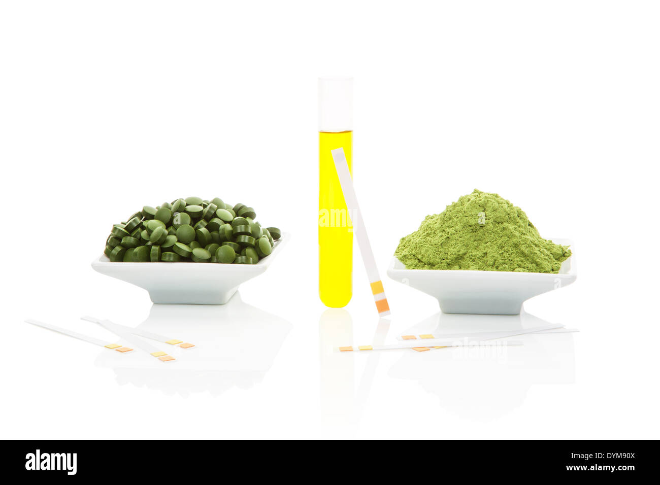 Urine sample in test tube, pH test strips, green pills and green ground