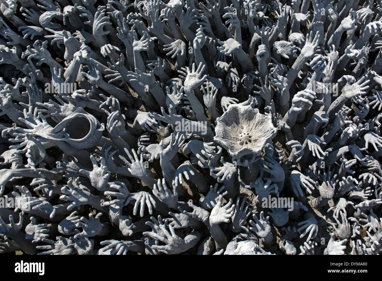 Depiction of hell, hands pleading for help at Wat Rong Khun, bridge to the entrance of the White Temple, by architect Stock Photo