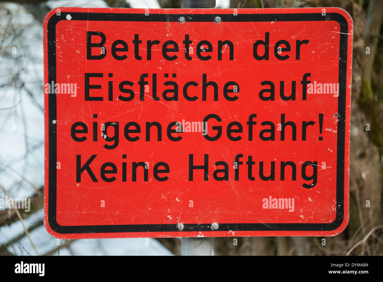 Sign 'Betreten der Eisfläche auf eigene Gefahr! Keine Haftung', German for 'frozen surface, enter at your own risk Stock Photo