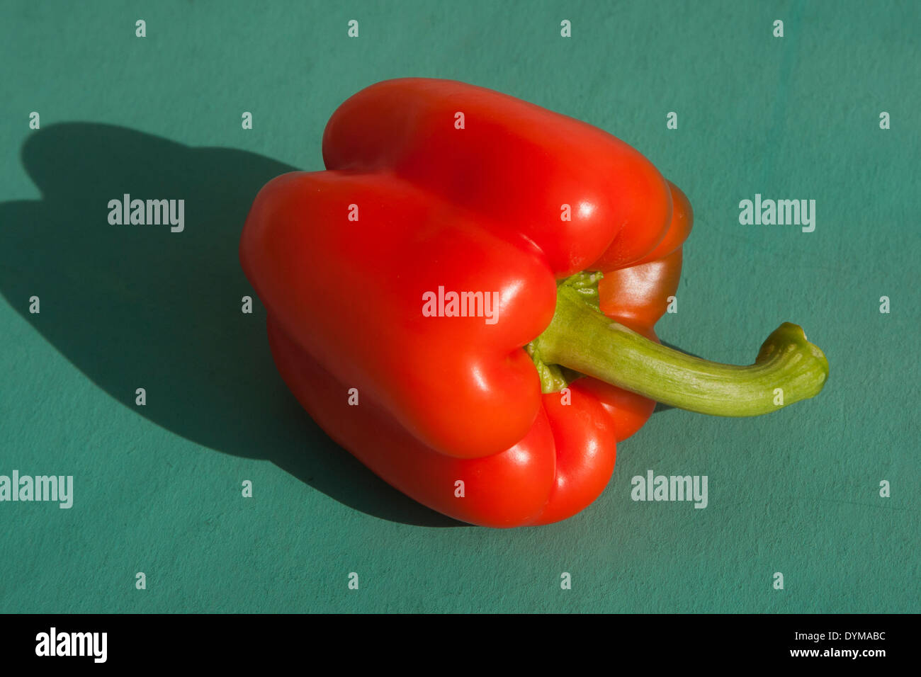 Red Bell pepper on green background Stock Photo - Alamy