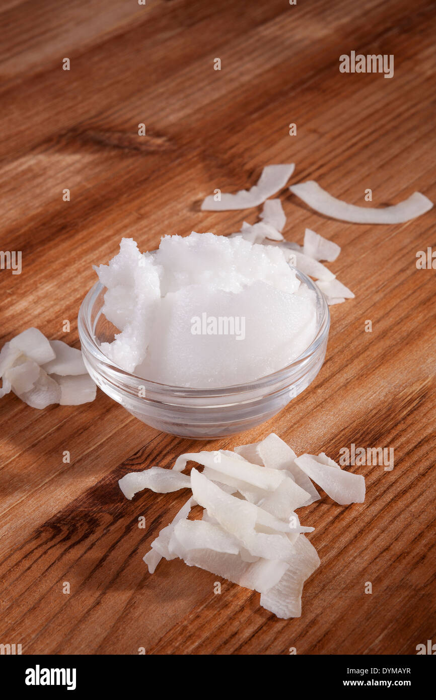 Organic Coconut Oil With Coconut Flakes On Wooden Background