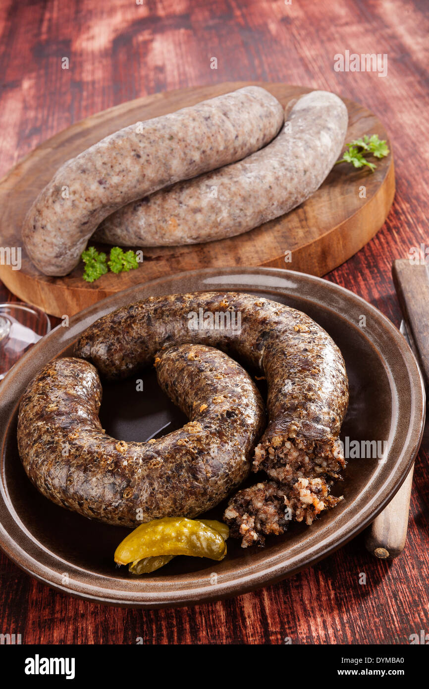 Blood sausage and rice sausage on wooden background. Culinary traditional european eating, rustic style. Stock Photo
