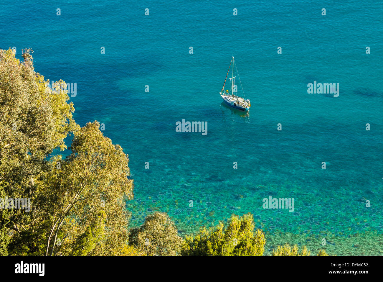 Yacht moored in crystal clear turquoise water offshore from this popular tourist town; Taormina, Catania Province, Sicily, Italy Stock Photo