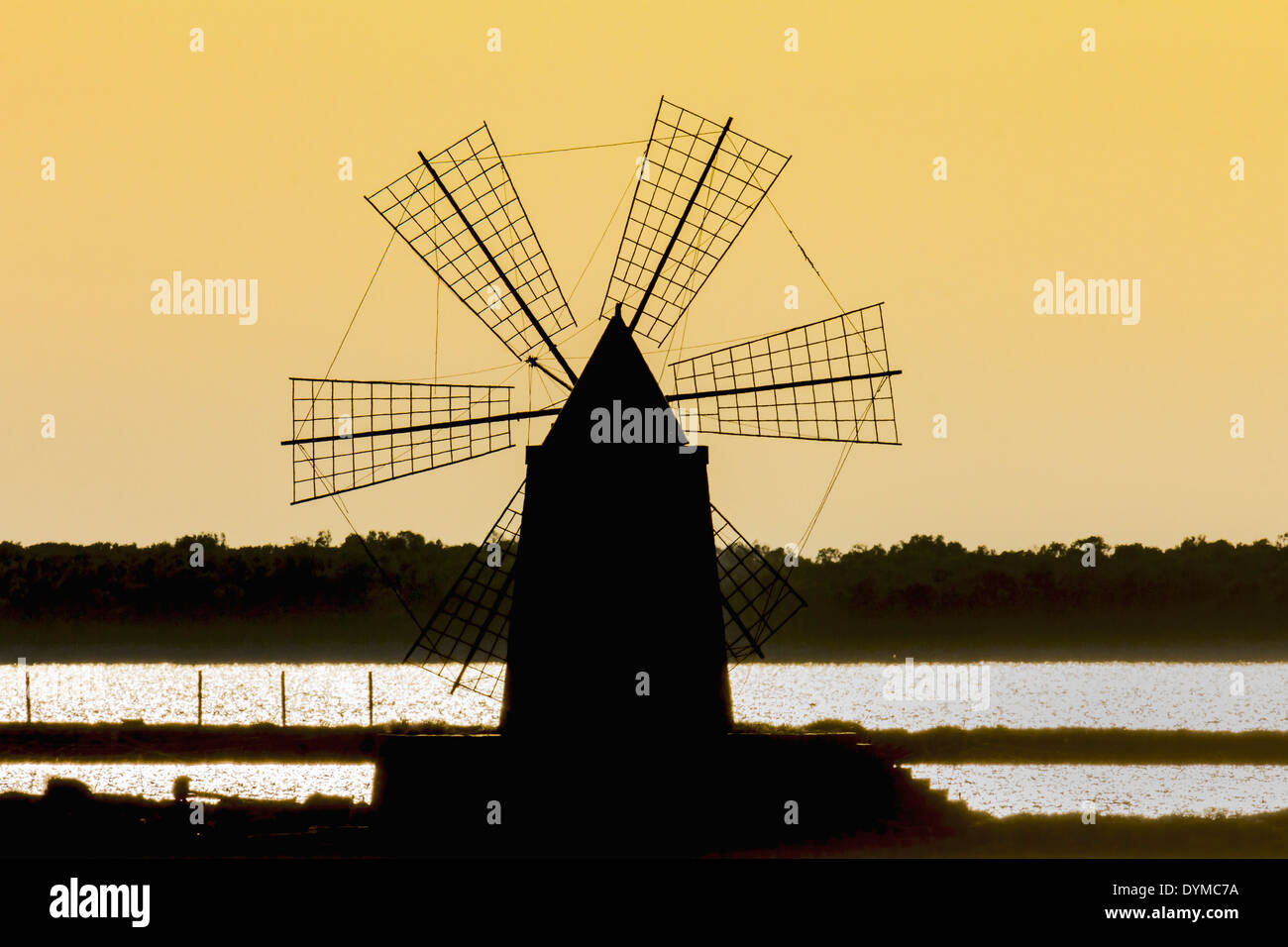 Silhouette of old windmill used to raise water from the Stagnone Lagoon into salt pans south of Trapani; Marsala, Sicily, Italy Stock Photo