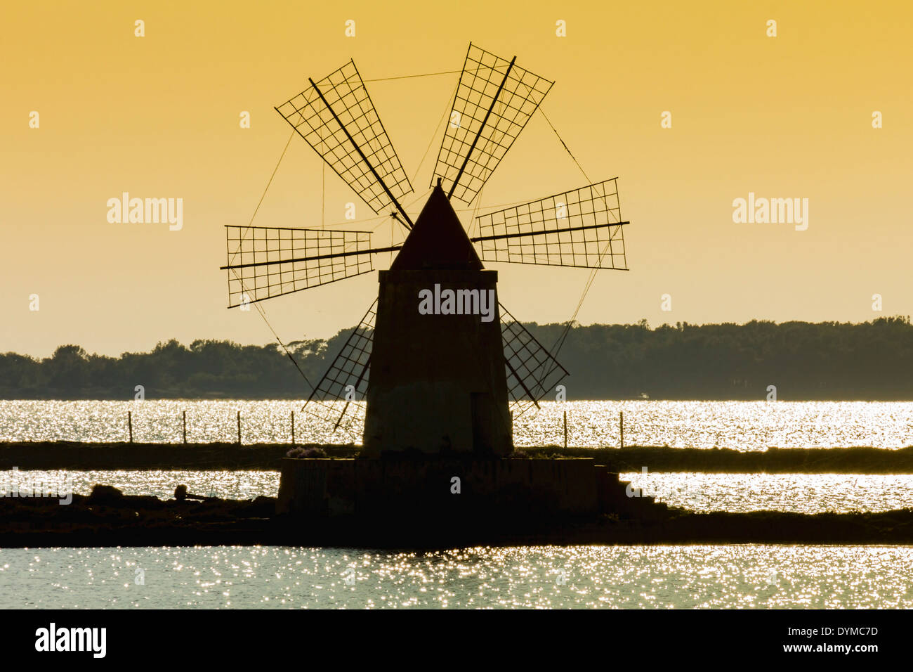 Silhouette of old windmill used to raise water from the Stagnone Lagoon into salt pans south of Trapani; Marsala, Sicily, Italy Stock Photo
