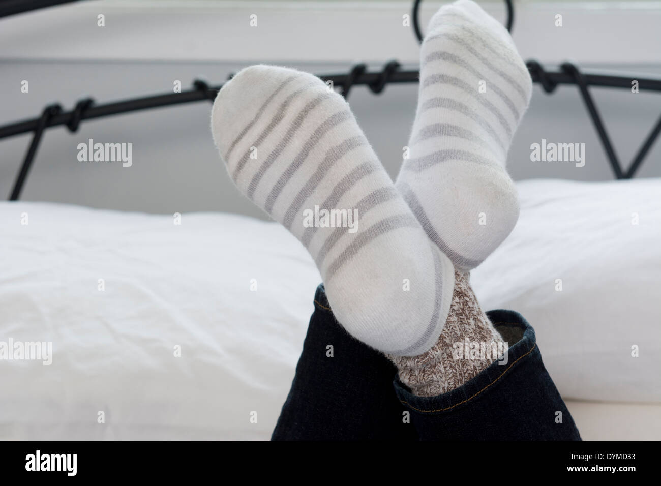 Teenage girls socks on crossed legs in bed in closeup shot Stock Photo