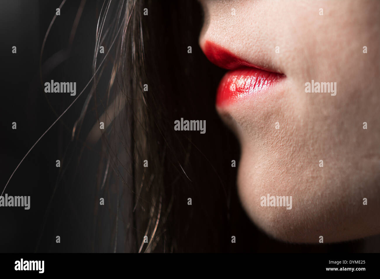 Closeup of young woman model showing hair and lips with red lipstick Stock Photo