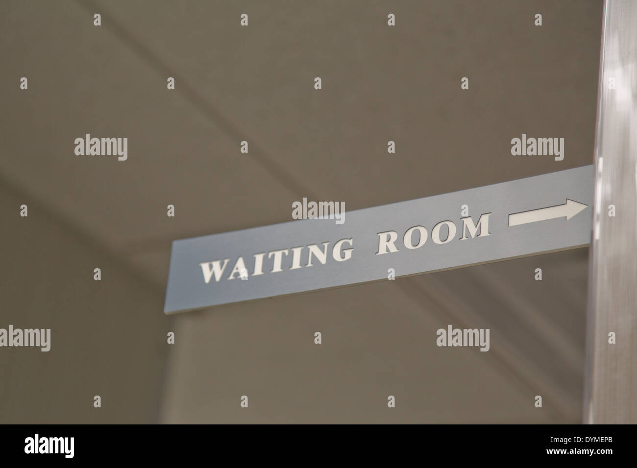 gray sign with right arrow and white print stating 'waiting room' Stock Photo