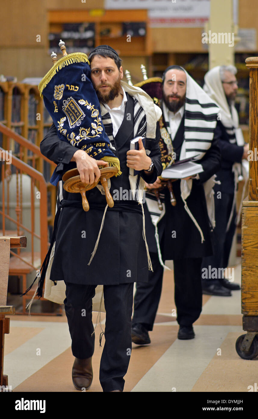 Religious Jewish men carry the Torah back to the holy ark during Stock ...