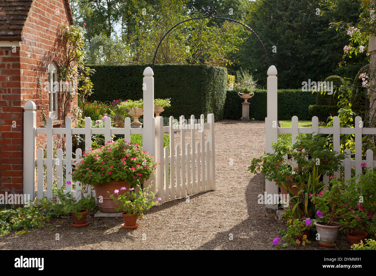 White picket fence and gated entrance to English summer garden Stock Photo
