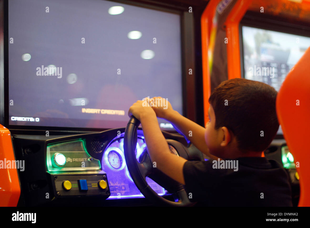 Indian toddler playing a racing game in a gaming zone in india Stock Photo